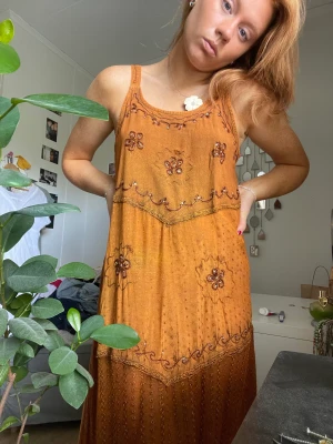 Klänning - Bronsaktig klänning med vackert mönster