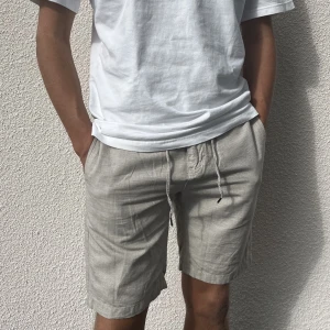 Linneskjorts - Supersnygga beigegrå linneshorts från East West i modellen Benson! I nyskick. Midjemåttet är 29, modellen brukar bära S/M och det passar fint! Skriv till mig vid frågor eller om du vill se fler bilder🫶🏻