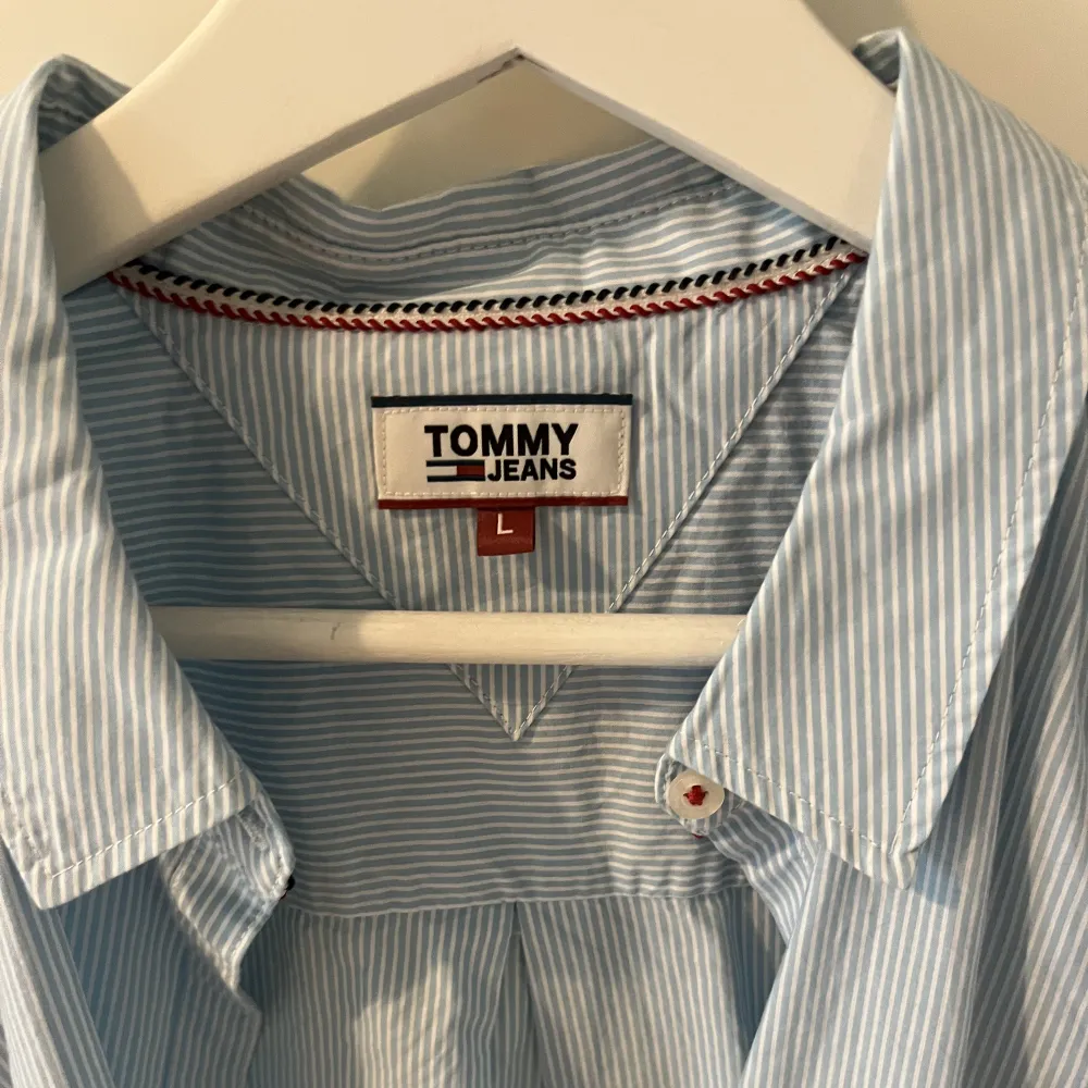 Blåvitrandig skjorta från Tommy Jeans. Figursydd. Upplever den något liten i storleken, så passar även M. Aldrig använd . Skjortor.