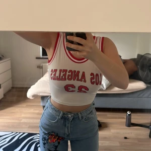 Linne - Vit röd linne. Står los angeles 23 på. Använd en gång är i bra skick. Är xs men passar nog s.