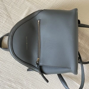 Tommy Hilfiger mini ryggsäck - Sjukt snygg grå Tommy Hilfiger mini ryggsäck. Ca 30x20x15cm. Mindre slitage på dragkedjan därav bra pris 