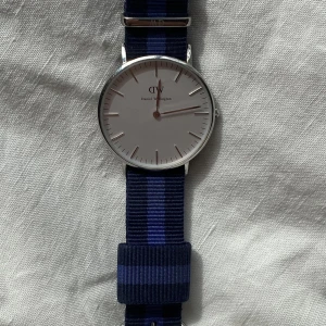 Daniel Wellington-klocka  - Klocka med band. Jättefint skick, behövs bara nytt batteri. 