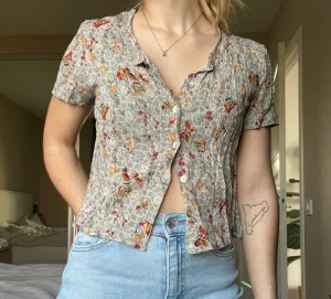 90-tals blus - Mönstrad crop top blus med knappar hela vägen på framsidan. Går att knäppa upp alla knappar. Lite 90-tals vibbar. Storlek: M (passar även för XS-S)