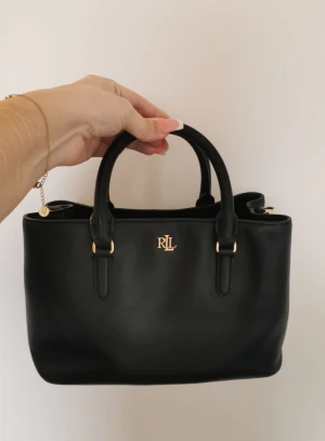 Ralph Lauren Marcy Handväska - MARCY 26-SATCHEL-SMALL Mått: H 20 x B 15 x D 20 cm  Inköpt för 4395kr ungefär 9mån sen. Använt med fint skick. Hämtas i Hjulsta eller möts upp i centrala Stockholm.  Kan fraktas mot kostnad  Priset kan diskuteras vid snabb affär 