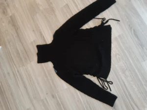 Stickad tröja - Väll använd, kragen kan man ha lång eller rulla ihop den se bild 2 och 3 för skillnad. På sidan kan man knytta och spänna den lite.