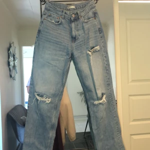 Jeans  - Snygga jeans med slitningar vid knän och lår. Raka i passform och höga i midjan. 