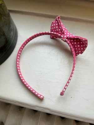 Diadem  - Ett diadem som är rosa med vita små hjärtan på. Jag änvänder inte detta lika ofta så därför säljer jag detta! 