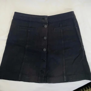 Svart kjol - Svart kjol från H&M med knappar . Är i fint skick!