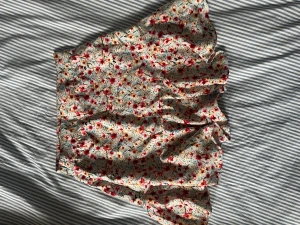 Sommarkjol - Gullig sommarkjol med blommigt mönster. Dragkedja på sidan.