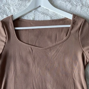 Ribbstickad topp - En lätt urringad topp från Shein i en beige/brun färg. Den är tunn, sval och perfekt i sommar. Ha även i åtanke att den är liten i storleken, så denna L passar mig som är 176 cm lång och bär storlek S/M. Köpte förra sommaren men glömde helt bort den. <3