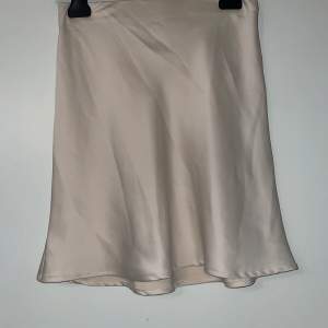 En beige färgad kjol från Bik bok aldrig använd strl xs 