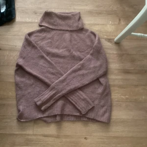 Rosa stickad tröja - En fin stickad rosa tröja med höghals nästan ny använd ett fåtal gånger köparen står för frakten 