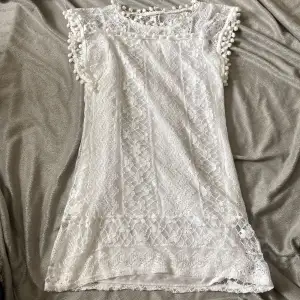 En vit spetsklänning som inuti har en ”underklänning”. Den är i storleken L och har en liten rosa fläck (se sista bilden)🤍