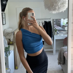 Blå one shoulder top - Snygg blå one shoulder top som är använd två gånger💕 går att ha på vilken axel man vill, materialet är lite ”glansigt” och såå fint💓