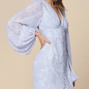 Adoore klänning - Superfin adooreklänning modellen positano. Perfekt till exempelvis midsommar! Jättefint skick och i storlek 34. Färgen är vit/ljuslila och säljs inte längre.