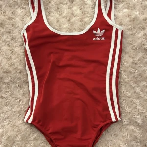 Adidas baddräkt / body  - Röd Adidas body / baddräkt i strl 34. I nyskick då den är fel storlek för mig tyvärr.  Men super fin! 