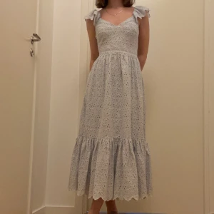 Ljusblå klänning med hålbroderi - Perfekt fest- och midsommarklänning. Inget trasigt, inga fläckar. Klänningen sitter bra på mig, jag är 164 cm lång och har oftast stl 34 i kläder. Priset inkluderar frakt!