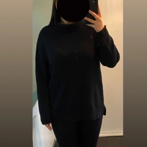 Stickad polotröja - Stickad svart tröja ifrån lager 157. Säljer likadan i beige, där finns bättre bild. Super mysig och stretchig. I strl M men passar även L. Säljer då den inte kommer till användning längre. Den har liten slits på båda sidorna. 