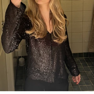 Paljett top - Säljer denna blusen ifrån gina tricot. Den är i ett mesh material med svarta paljetter. Mycket bra skick endast använd en gång! Köpare står för frakt💗
