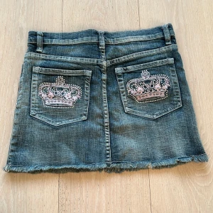 Victoria Beckham kjol - Jag säljer min jättefina Victoria Beckham kjol med rosa kronor då den tyvärr inte passar mig. Midjemått 36cm rakt över och skulle gissa på strl 34/36. Köpt på plick och aldrig använd. Tveka inte med att fråga 💕💕