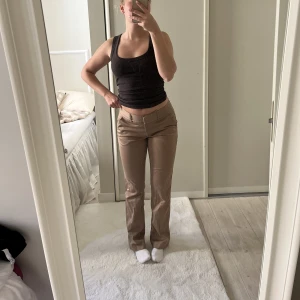 lågmidjade kostymbyxor  - Byxorna är lågmidjade och i en guld/brun super fin färg, jag är 164 cm och längden passar perfekt 