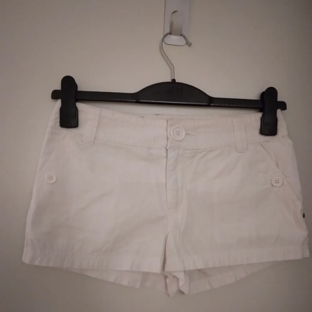 Vita korta shorts från H&M. Strlk 34 / XS. Har flera fickor. Stängs med dragkedja och knapp. Flera fickor, alla med knapp. Material: Lite kraftigare men lent bomullstyg. Felfria. Endast använda 1 gång och tvättade efter. Säljer även svarta likadana.. Shorts.