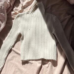 Långärmad tröja med turtelneck - Vit tröja med turtelneck ifrån Bershka i väldigt skönt material,den har en tråd på framsidan av tröjan men det stör inte så mycket, storlek  S men passar XS och väldigt stretchig