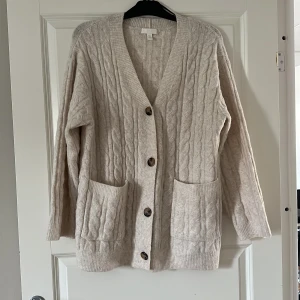 Kofta  - En lite längre kabelstickad kofta från H&M.