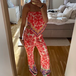 Byxa och topp - Byxor med slits och topp man knyter i bak. Går att ta av banden för att få toppen bandeu. 