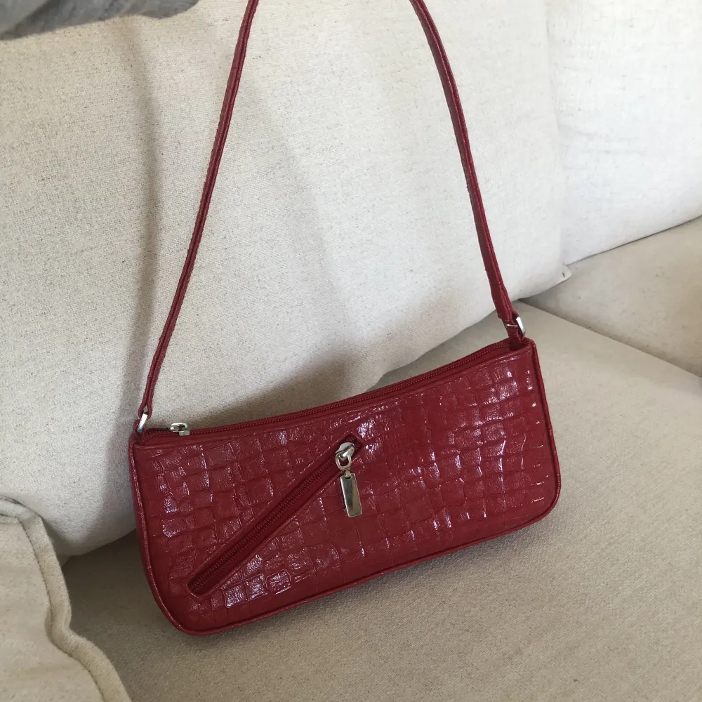 Jättesöt röd handväska med snygg detalj på baksidan. Har ett innerfack också. . Väskor.