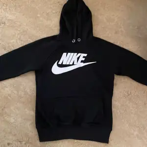 Den är svart med vit märke där det står ”Nike”
