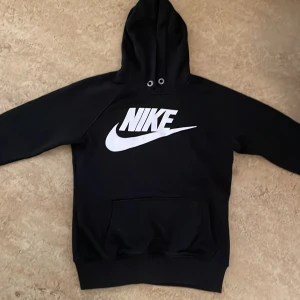 Nike hoodie - Den är svart med vit märke där det står ”Nike”