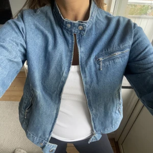 Jeansjacka - Så snygg jeansjacka med knäppe upptill, dragkedja och fickor. Står L på lappen men skulle säga att den är mer som en M. Superfint skick! DM för fler bilder. 