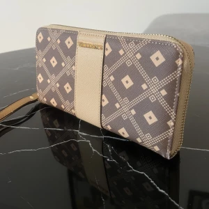 Plånbok  - Brun/beige plånbok från Vezzano. I fint skick! 20x11cm, 16cm rem.