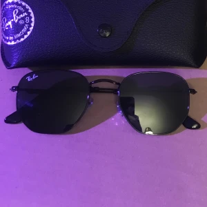 Helt nya Ray-Ban Hexagonal svarta solglasögon  - Mina helt nya Ray-Ban Hexagonal svarta solglasögon säljer jag nu för dom ligger bara i byrålådan och dammar.  Nypris: 2299:- Snabb affär 599:- plus frakt. 
