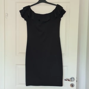 Svart klänning - Tajt svart klänning med volang upptill. Knappt använd.