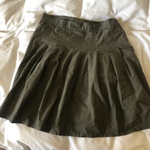 Armégrön pleated kjol strl 46 - En kortare veckad kjol i gott skick. Storlek 46 från märket royal regate. Midjemått på 84cm å 55cm lång. Köparen står för frakt och Dma gärna vid frågor eller funderingar! 
