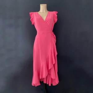 Sommrig omlottklänning i rosa  - Super fin sommrig omlottklänningen i rosa! Från en lokalbutik på västkusten. Aldrig använd och lappen sitter kvar 💗  Väldig flexibel i storleken, skulle passa mellan xs till m. Super fint och skönt material.  Perfekt till midsommar! 