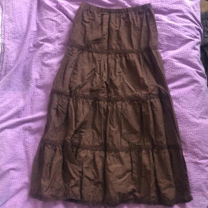 Brun maxiskirt med spets - Brun maxiskirt med spets Längd 90cm  Bred vid midjan 65cm  Kjolen har inte blivit använd