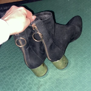 Svarta boots med guldklack  - Använda måttligt men går att rengöra då man kan se på bilden att de är lite små smutsiga.