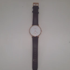 Klocka - Fin brun klocka, enkel att matcha med. Klockan fungerar och passar perfekt. Ny pris 1695, säljer för 750 eller bud.