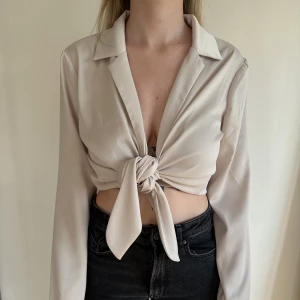 Beige blus - Beige blus med knyt från Bik Bok, storlek S. Aldrig använd.