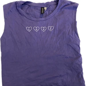 Ett Lila linne med hjärtan - Köpte denna på H&M för några år sen, fortfarande väldigt fin! Storleken är XS men jag kan fortfarande ha den som en ”liten topp” o jag bär kläder i M-L