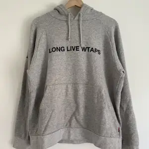 En basic hoodie från japanska märket Wtaps. Använts flitigt, har två små fläckar vid kängerufickan. Annars inga flaws. Storlek M, sitter lite oversized. 