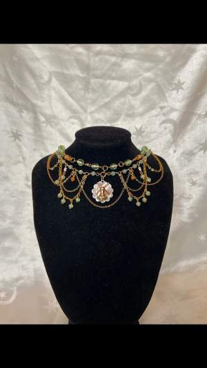 Väderkvarn:) Grönt och orange handgjort halsband med guldiga kedjor. Förlängningskedja finns på halsbandet <3 Omkrets: 36-41 cm