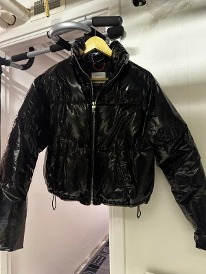 Svart lack jacka - Finns inga problem, hål eller liknade. Den går att justera i midjan. Passar allt mellan xs/s/m beroende på hur man vill att den ska sitta.