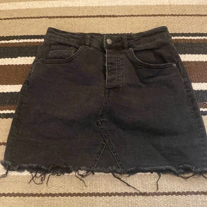Jeanskjol - Mörkgrå jeanskjol från Gina tricot. Stl 36, använd ett fåtal gånger, fint skick. 150kr