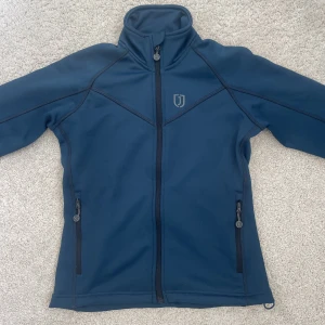 Ridtröja jacson  - Ridtröja från jacson. Använd fåtal gånger och ser sprillans ny ut. Köpt för 500kr har jag för mig. Säljer endast för 220kr priset kan diskuteras LITE.  Inga tecken på användning. Tröjan är i en fin blå/grön färg storlek xs