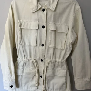Gräddvit Jeansjacka - Perfekt till sommar/vår Helt oanvänd!  (Fästet till lappen sitter fortfarande kvar men lappen har ramlat av).  Storlek xs, skulle säga att den passar S också!  Går att spänna runt midjan vilket är snyggt😍