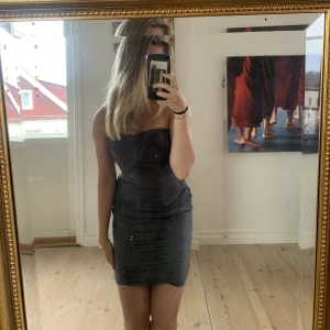 Grå korsettklänningen  - Supersnygg grå korsettklänning i st 34 från HM. Dragkedja i ryggen och gummi vid brösten så den sitter uppe. Endast använd 1 gång. 